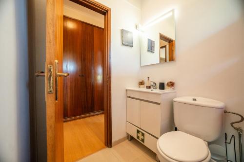 a bathroom with a toilet and a wooden door at Travessa in Lisbon