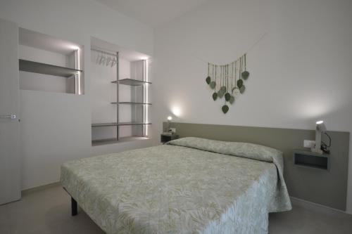 a bedroom with a bed in a white room at SIT Holiday Homes in Lido delle Nazioni