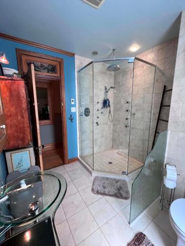 a bathroom with a shower with a glass shower stall at La Tournesol in Granby