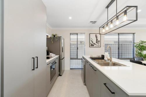 a kitchen with a sink and a refrigerator at Drift at Shorehaven Coast in Alkimos