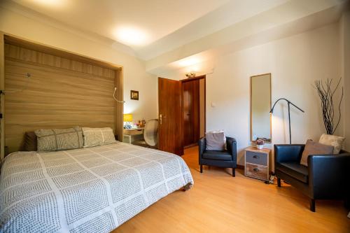 a bedroom with a bed and two chairs at Travessa in Lisbon