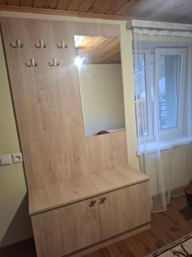 a wooden cabinet with a mirror in a room at Eka's house in Kazbegi Goristsikhe in Itʼkhvisi