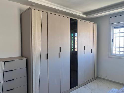 a room with white cabinets and a window at Ali Building in Wadi Musa