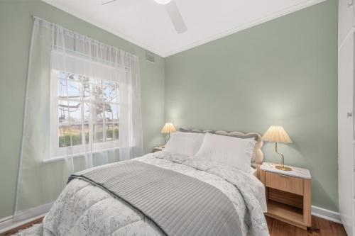 a white bedroom with a bed and a window at The Retreat, Barossa Valley in Lights Pass
