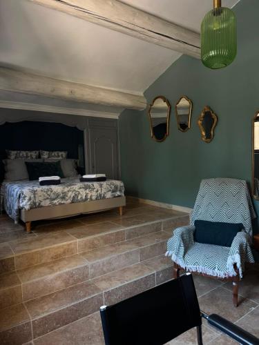 a bedroom with a bed and a chair and mirrors at LA BASTIDE De La Colline in Cavaillon