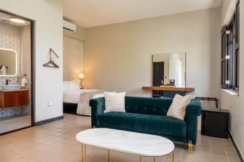 a living room with a green couch and a bed at The Oliver Hotel - Adults Only in San Juan