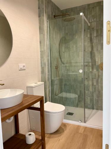 a bathroom with a toilet and a glass shower at Quinta del Mar suites - Costa Quebrada in Soto de la Marina