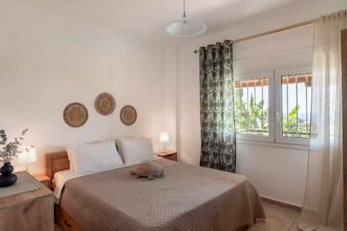 a bedroom with a bed and a window at Sunset Luxury Potidea in Metókhion Patriotikón