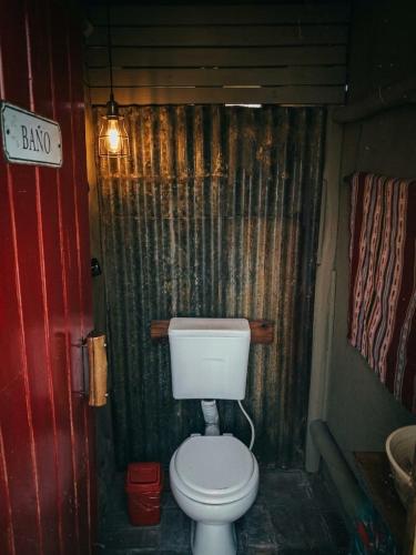 a bathroom with a toilet and a curtain at Glamping Traslasierra Carpa Sur in San Javier