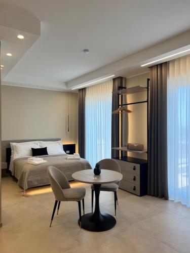 a bedroom with a bed and a table and a chair at Manoli Luxury Rooms in Vieste
