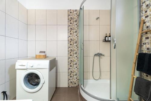 a bathroom with a washing machine and a shower at Sunset Luxury Potidea in Metókhion Patriotikón