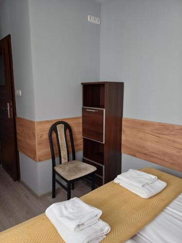 a bedroom with a bed and a chair and a desk at Santa Maria in Kołobrzeg