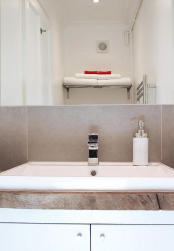 a bathroom sink with a soap dispenser on it at West Hill Apartment in Brighton & Hove