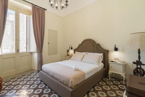 a bedroom with a bed and a chandelier at Dimora la Fuga in Zollino