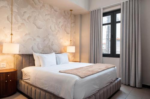 a bedroom with a large bed and a window at The Oliver Hotel - Adults Only in San Juan