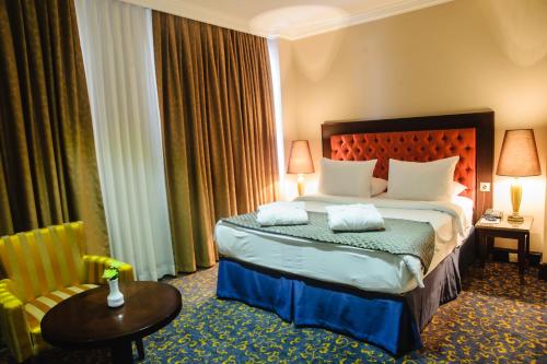 a hotel room with a bed and a table at Hotel Intourist Palace Batumi in Batumi