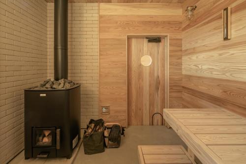 a room with a woodburning stove in a room at JOKIJOKI Hakuba in Hakuba