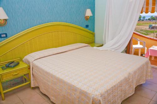 a bedroom with a bed and a table and a window at Hotel Rivadoro-Spiaggia ombrellone e lettini-Piscina-Parcheggio in Martinsicuro