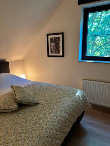 ein Schlafzimmer mit einem Bett und einem Fenster in der Unterkunft Vakantiewoning Bisonder in Bilzen
