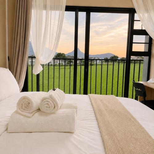 a bed with towels on it with a large window at Jets Stay Property in Cape Town