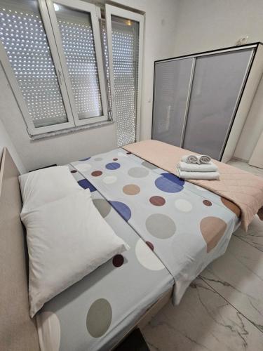 a bed with polka dot sheets and pillows in a room at XXL APARTMENTS CiTY CENTAR 1 in Bitola