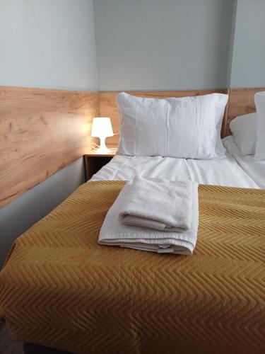 a bed with two towels sitting on top of it at Santa Maria in Kołobrzeg