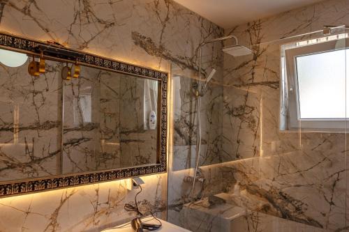 a bathroom with a mirror and a sink at Lux Stays in Prishtinë