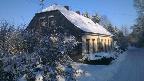 a house with a snow covered roof on a street at Ferienwohnungen Alte Schule in Elchweiler