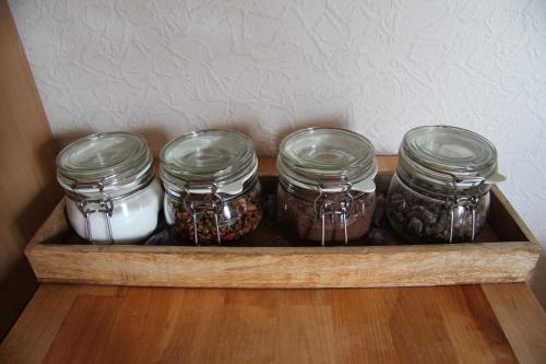 four jars of food in a wooden drawer at Ferienwohnungen Alte Schule in Elchweiler