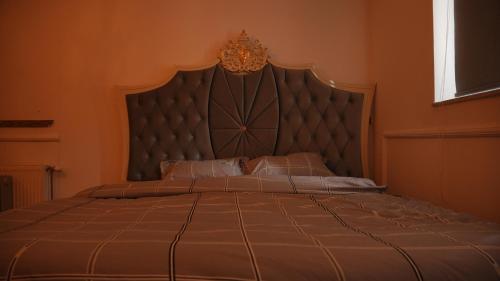 a bedroom with a large bed with a large headboard at Lux Stays in Prishtinë