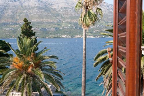 a view of a body of water with palm trees at Apartments Jasmina in Korčula