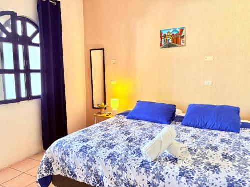 a bedroom with a bed with blue pillows at Blue Moon Hostel in Antigua Guatemala