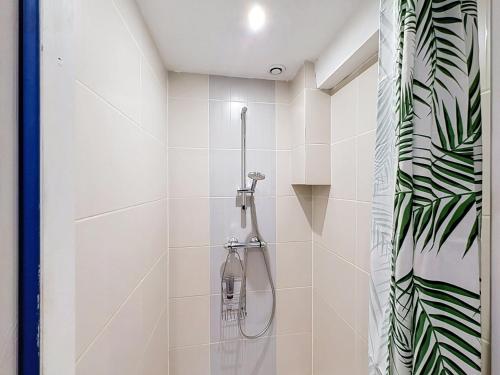 a bathroom with a shower with white tiles at La Grande Chaumiere in Saint-Vulbas