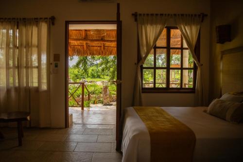 a bedroom with a bed and an open door at Hotel Aldea Katún in Izamal