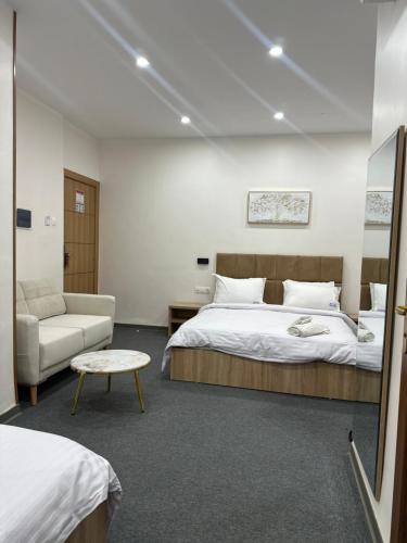 ein Schlafzimmer mit einem Bett, einer Couch und einem Stuhl in der Unterkunft Cristam in Biskra