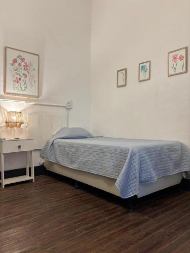 a bedroom with a bed and a table with a lamp at Posada Las Chacras in Ciudad Lujan de Cuyo