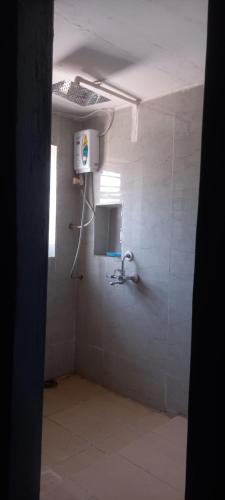 a bathroom with a shower in a white wall at THUBE Saheb B&B in Jabalpur