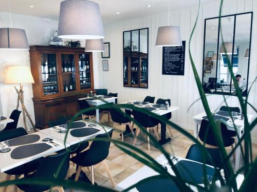 a restaurant with tables and chairs in a room at Hôtel Le Galet Bleu in Fouras