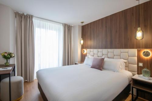 Un pat sau paturi într-o cameră la Le Cetai Cannes Beach Hotel