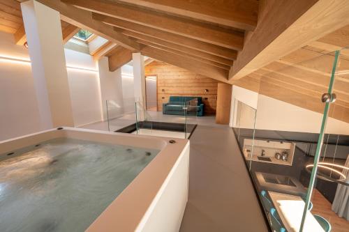 a hot tub in a room with wooden ceilings at Echo - Private Spa Apartments in Ponte di Legno