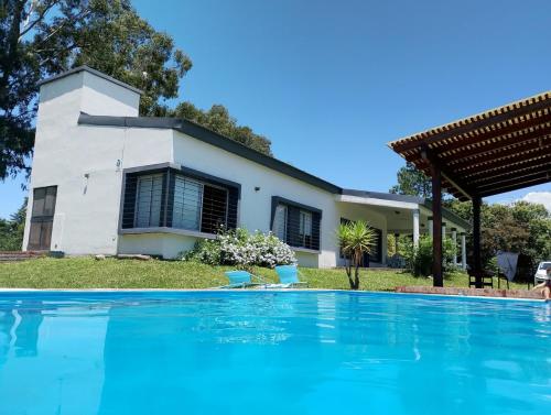 a house with a swimming pool in front of a house at El Prado Chico, Casa de Campo in Salta