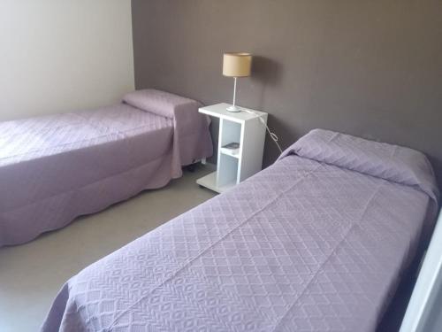a bedroom with two beds and a table with a lamp at El Prado Chico, Casa de Campo in Salta
