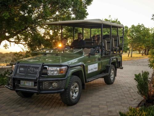 a green jeep with people riding in it at Founders Lodge by Mantis in Paterson