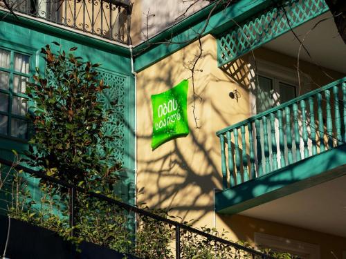 a green building with a sign on the side of it at ibis Styles Old Tbilisi in Tbilisi City