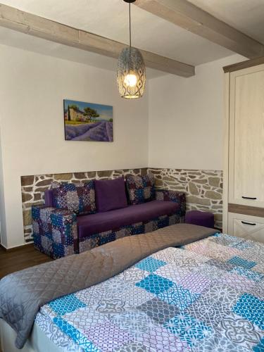a bedroom with a bed and a couch at Patakparti Pihenő in Cserépfalu