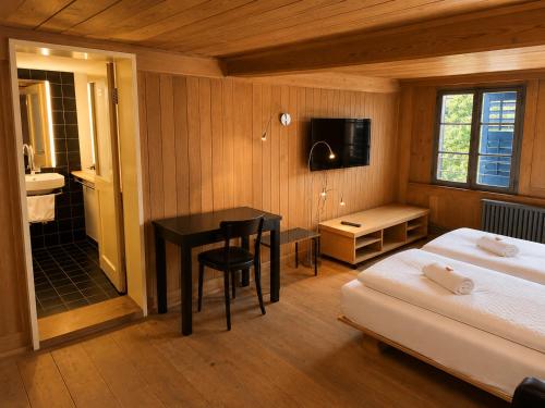 a bedroom with a desk and a bed and a bathroom at Klösterli Malters in Malters