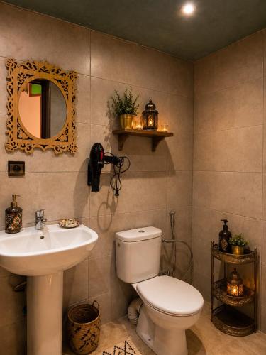 a bathroom with a toilet and a sink and a mirror at Riad Hamad Tijani in Fez