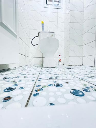 a bathroom with a toilet on a tiled floor at Dyden luxury appartement in Douala