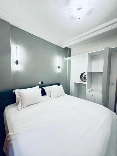 a bedroom with a large white bed with white pillows at Dyden luxury appartement in Douala