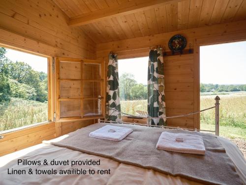 a bedroom with a bed in a wooden cabin at The Hoppers Hut in Weald